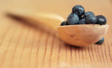 Blueberries on a wooden spoon. Shallow depth of field.の写真素材