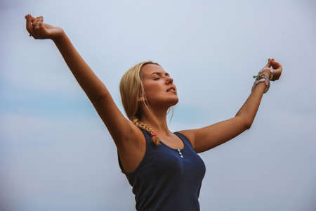Portrait of happy young girl with stretched arms enjoying lifeの写真素材