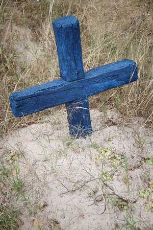 Old painted wooden cross on the grave of the rural cemeteryの写真素材