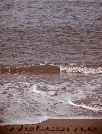 Welcome written in a sandy beachの写真素材
