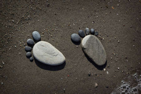 Stone arranged like a footprint on the beachの写真素材