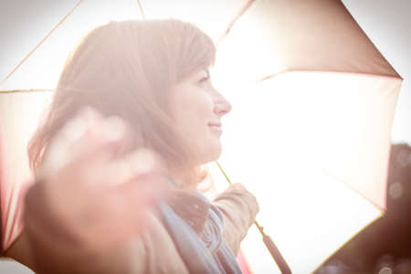 Girl with an umbrella in the rays of a sunの写真素材