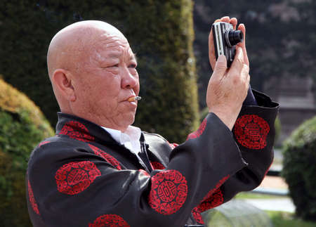 VIENNA, AUSTRIA - April 29: Chinese tourist with cigarette in mouth photographed in the park on April 29, 2009 in Vienna, Austria.のeditorial素材