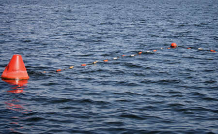 Floating red navigational buoy on lake