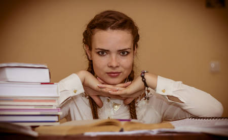 Girl sitting at a table near the book