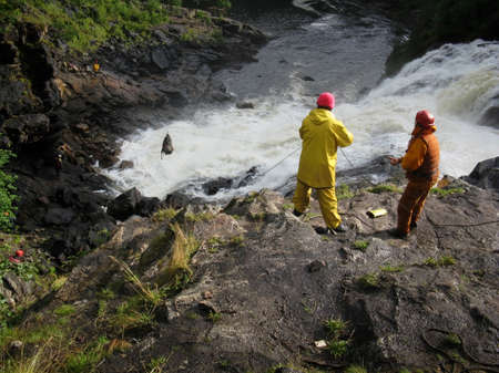 BUG, UKRAINE - AUGUST 12 - Man in protective helmets and life jackets trafficked backpack through the waterfall  in Bug on August 12, 2008.のeditorial素材