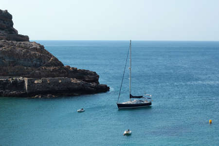 Sailing boat in the Mediterranean sea with mountains on backgroundの写真素材
