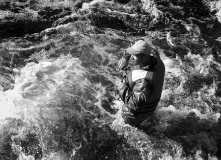 KOLSKYY, RUSSIA - 11 AUGUST 2008: Man in the life vest standing in the water of the mountain riverのeditorial素材