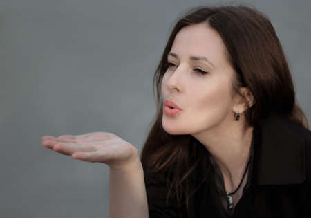 Woman sends an air kiss. Shallow depth of field.の写真素材