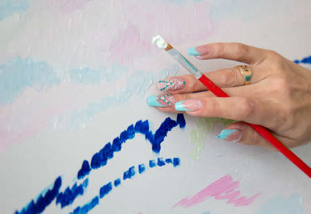 Hand with brush and paintの写真素材