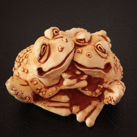 Figures of two ceramic embracing frogsの写真素材