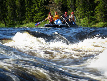 KOLA PENINSULA, RUSSIA - 16 AUGUST 2008: Four men on an inflatable catamaran  overcome the threshold of the turbulent riverのeditorial素材