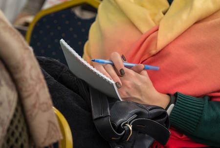 Female hands with pen and notebook. Shallow depth of field.