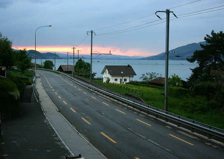 Road with lake and mountains in the background in Switzerland