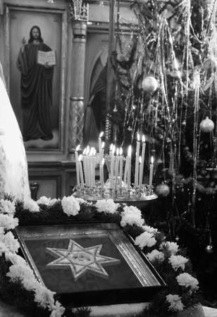 Icon and candles burning in church during christmas service. Shallow depth of field.の写真素材