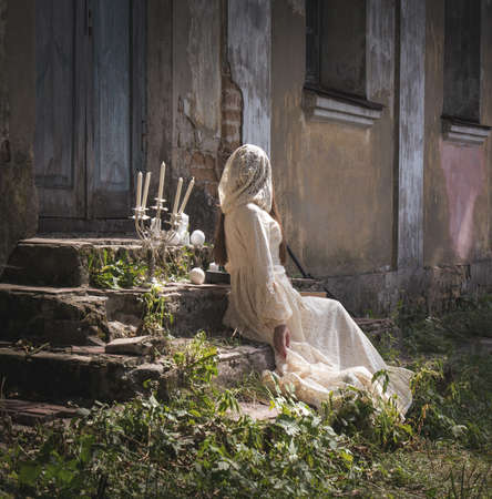 Woman in a long dress sit on gothic style staircaseの写真素材