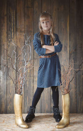 Cute pre-teen girl posing on wooden backgroundの写真素材