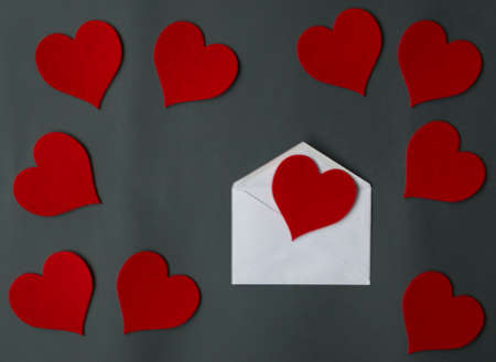 Love letter envelope with red hearts on gray backgroundの写真素材
