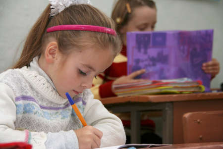 VOLODYMYREC, UKRAINE - 03 November 2008: Child with pens and notebooks writing test in classroom at rural schoolのeditorial素材