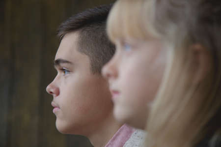 Profiles of young brother and little sister. Shallow depth of field, focus on boy.の写真素材
