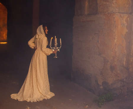 Mysterious woman in dress with candlesの写真素材