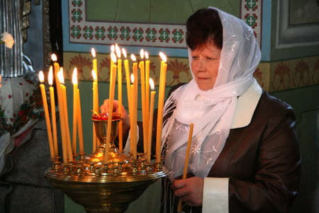 VOYUTYN, UKRAINE - 14 October 2008: Ukrainian parishioners of the Orthodox Church light up candles during the religious celebration Pokrovのeditorial素材