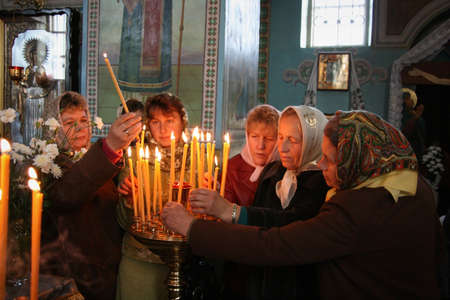 VOYUTYN, UKRAINE - 14 October 2008: Ukrainian parishioners of the Orthodox Church light up candles...