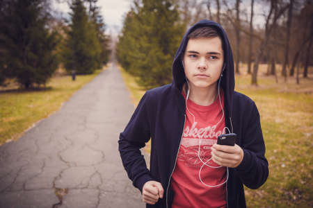 Male runner listening to music on mobile phone. Running, jogging, cardio, sport, active lifestyle concept.の写真素材