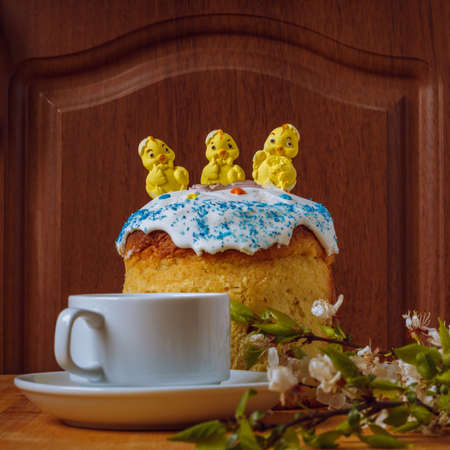 Easter cake with chickens on top and cup on tableの写真素材
