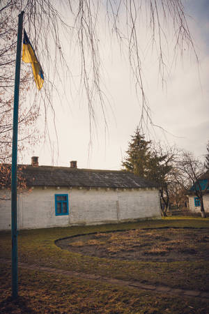 National flag and old-fashioned vintage white one roomed schoolhouse in Ukraineの写真素材