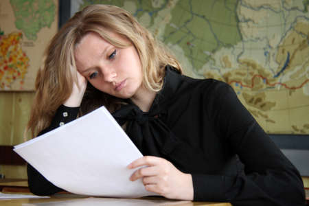 LUTSK, UKRAINE - 30 May 2014: Unknown female blonde student reading in class at universityのeditorial素材