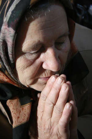 LUTSK, UKRAINE - 14 October 2008: Old woman praying in local churchのeditorial素材