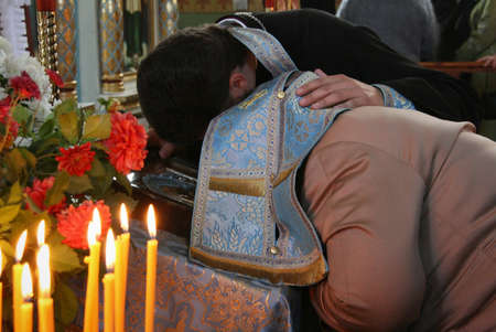 VOYUTYN, UKRAINE - 14 October 2008: Priest covered robe head of woman during confession in churchのeditorial素材