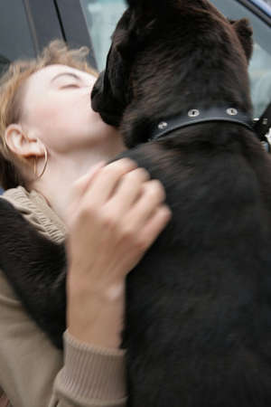 LUTSK, UKRAINE - 20 June 2009 - Woman with dog licking her face in parkのeditorial素材