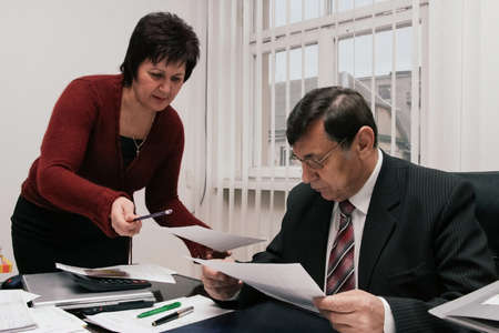 LUTSK, UKRAINE - 22 January 2009: Female showing document to her boss in the officeのeditorial素材