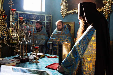 VOYUTYN, UKRAINE - 14 October 2008: Orthodox priests in altar during holiday prayers at local church