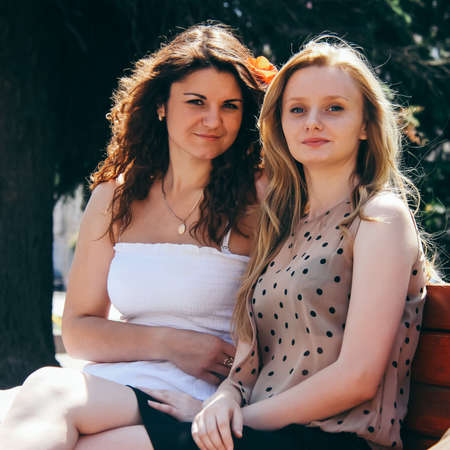 LUTSK, UKRAINE - 7 June 2014: Two unknown girls sitting on bench and posingのeditorial素材