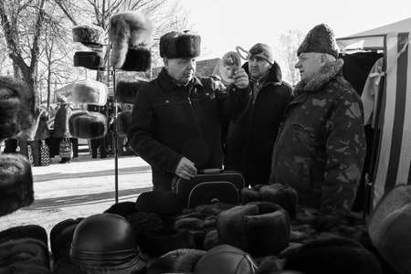 ZABOLOTTIA, UKRAINE - 20 January 2009: Men tries a new fur hat and looks in the mirror at local market in winterのeditorial素材