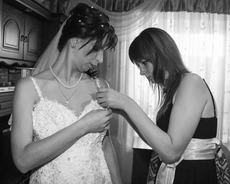 LUTSK, UKRAINE - 30 August 2009: Bride friend is helping to dress her before weddingのeditorial素材