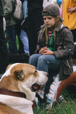 LUTSK, UKRAINE - 20 June 2009: A little girl and dog outdoors in park