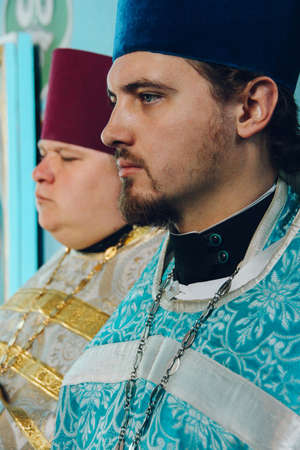 VOYUTYN, UKRAINE - 14 October 2008: Orthodox priests during holiday prayers in local church