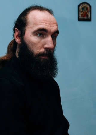 KUPYCHIV, UKRAINE - 30 January 2009: Christianity priest with beard in cassock posing at home