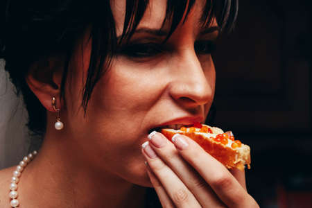 LUTSK, UKRAINE - 30 August 2009: Woman eating sandwich with red caviarのeditorial素材
