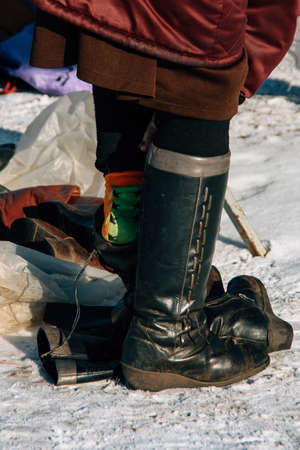 Woman sits boots on street in winterの写真素材