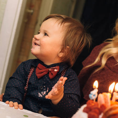 Funny baby is eating a tasty cake