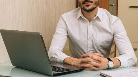Focus on hands of business person. He is sitting at table. Shallow depth of field.の写真素材
