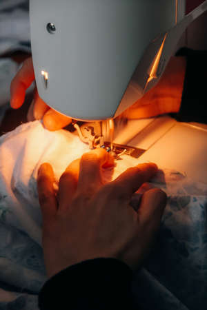 Female hands sewing on a machine