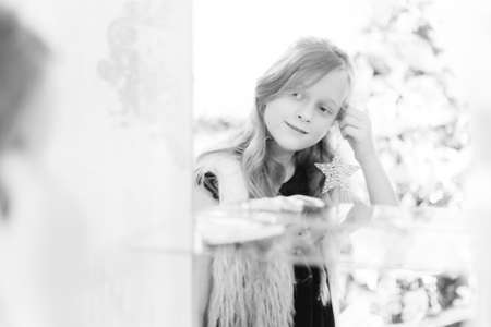 Little girl puts earrings and looking in mirror. Shallow depth of field. の写真素材