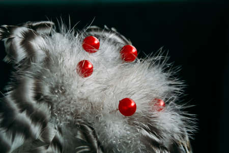 Artificial flower made from feathers and beads on dark with selective focusの写真素材