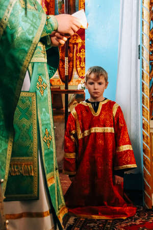 LUTSK, Volyn / UKRAINE - October 14 2008: Little sextons is kneeling in altar during holiday prayersのeditorial素材